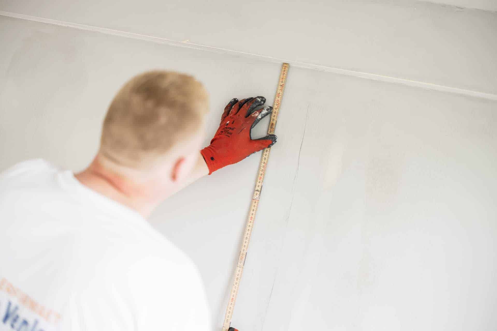 Væg måles af maler i Hørsholm